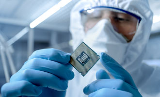Man in clean suit holding a silicon processor