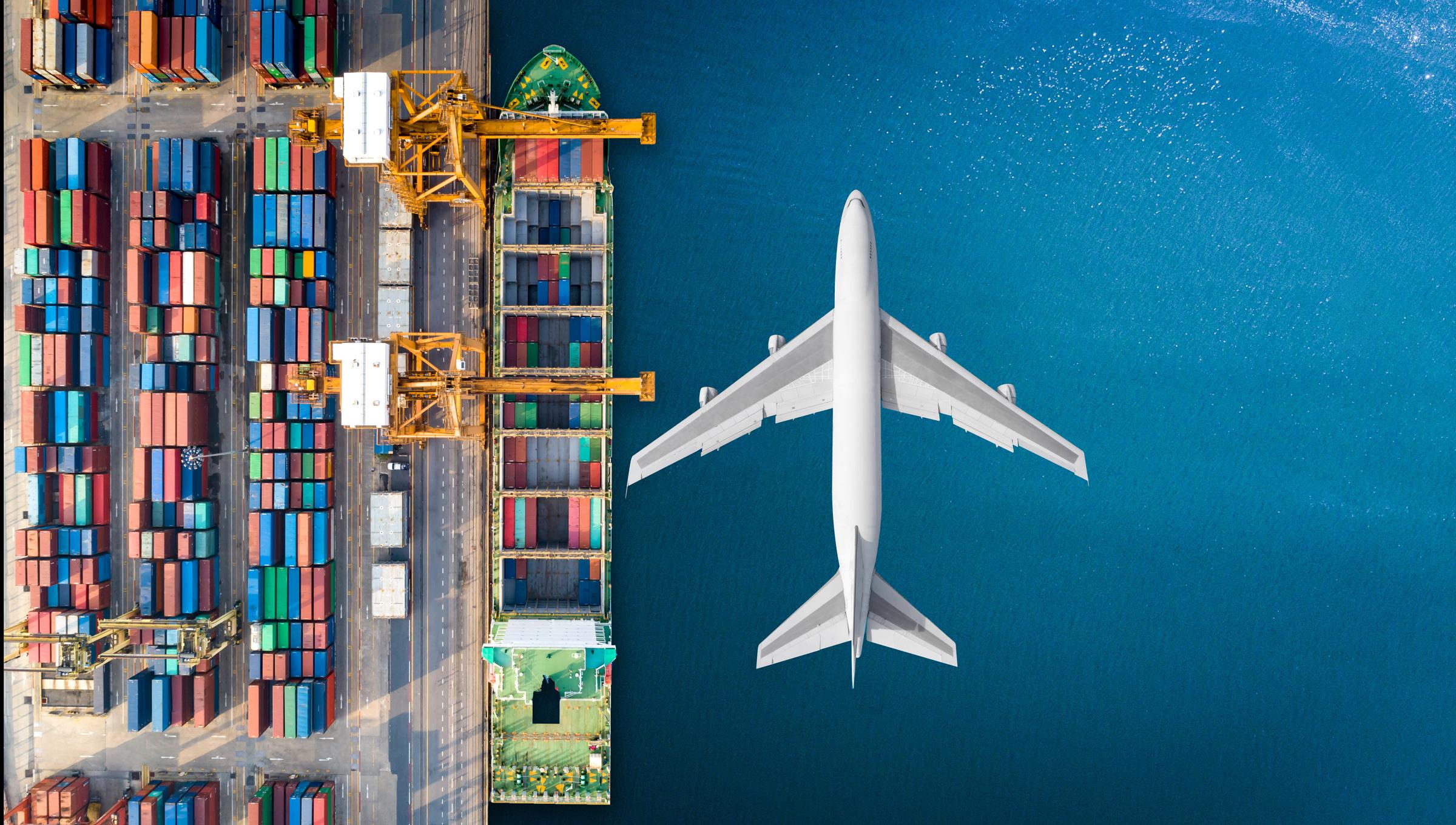 View of cargo containers, a container ship, and an airplane by the ocean, symbolizing multiple modes of international transportation.