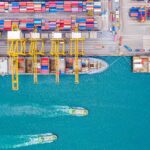 Stacked containers being loaded onto cargo ships at a port