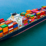 A large container ship carrying colorful shipping containers across the ocean, representing global shipping market trends in 2025 and evolving trade challenges