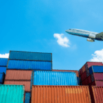 Commercial airplane flying over stacked cargo containers, symbolizing efforts to Optimize Air Freight Shipping from China to the U.S.