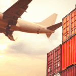 An aircraft flying over the container yard