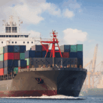 Large container ship carrying cargo at port, representing global freight strategies for retail and technology supply chains