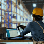 Warehouse worker scanning inventory data into a laptop as part of a customs compliance strategy