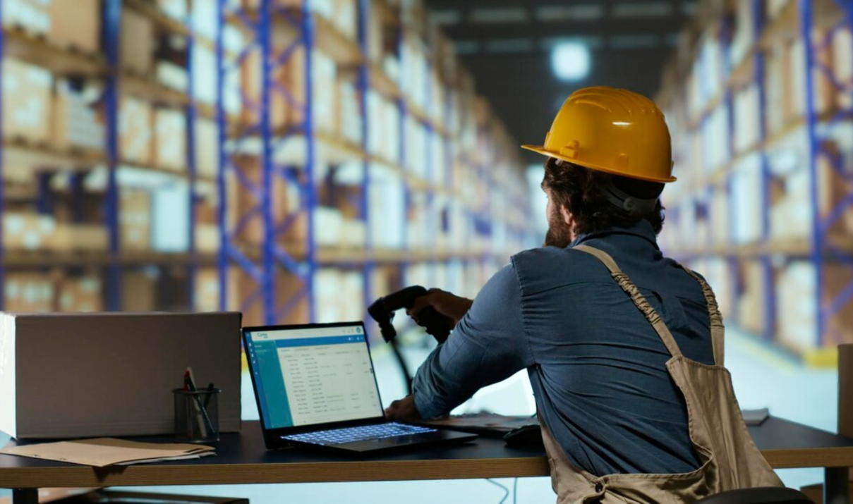 Warehouse worker scanning inventory data into a laptop as part of a customs compliance strategy