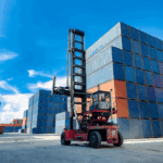 Shipping containers stacked at a port with a forklift moving cargo, symbolizing global trade and supply chain logistics