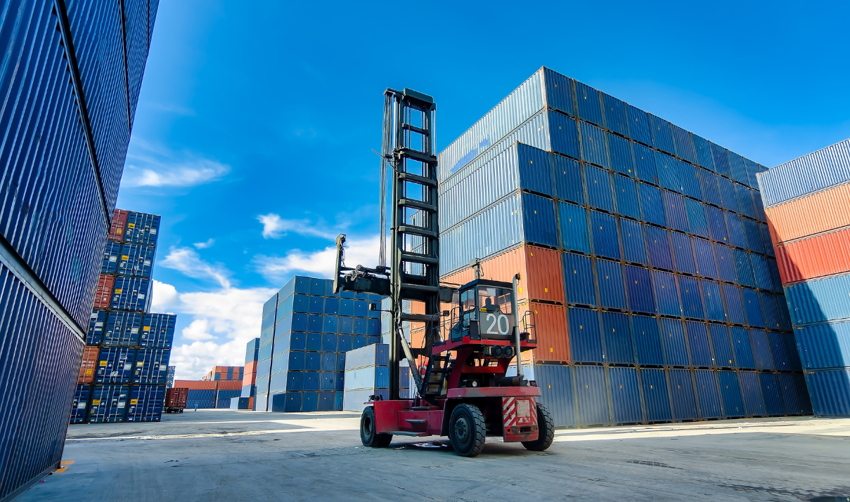Shipping containers stacked at a port with a forklift moving cargo, symbolizing global trade and supply chain logistics