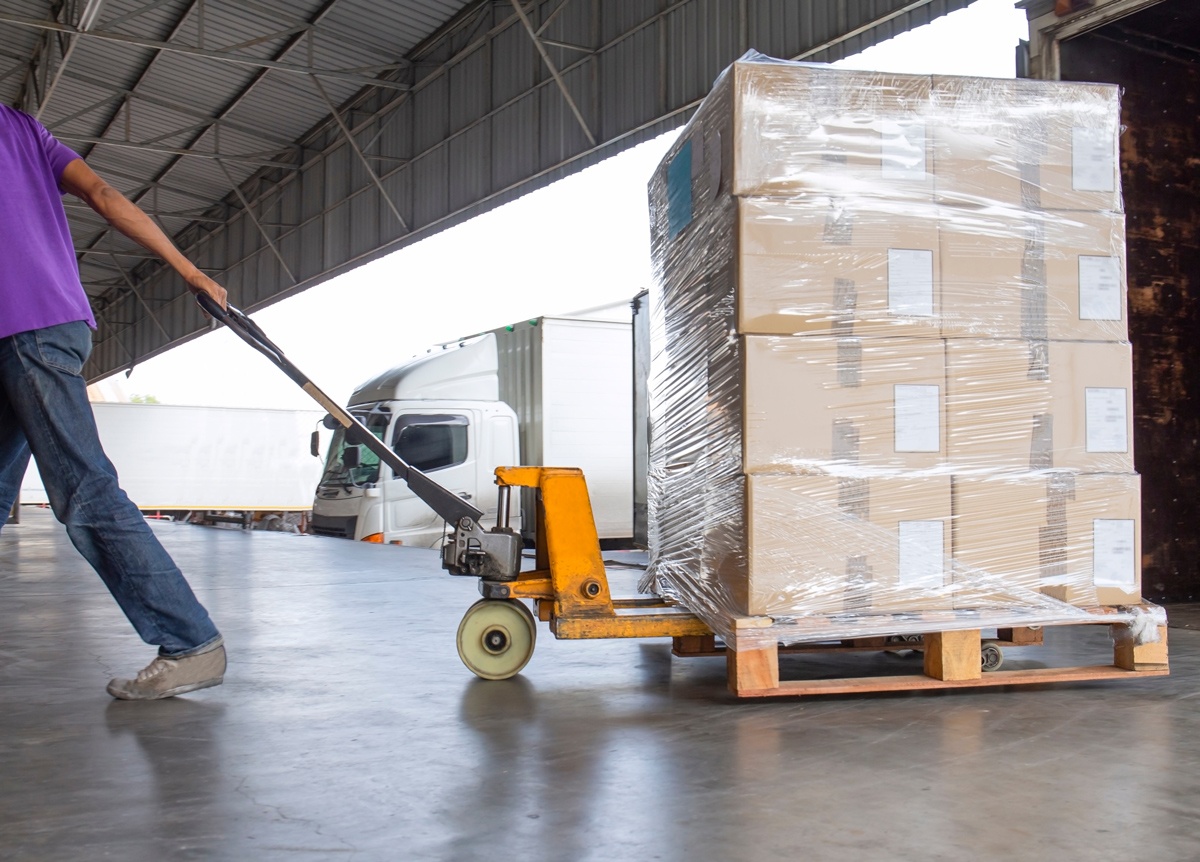 cross-border-shipping-warehouse-handling Warehouse worker preparing freight for cross-border shipping and regional distribution