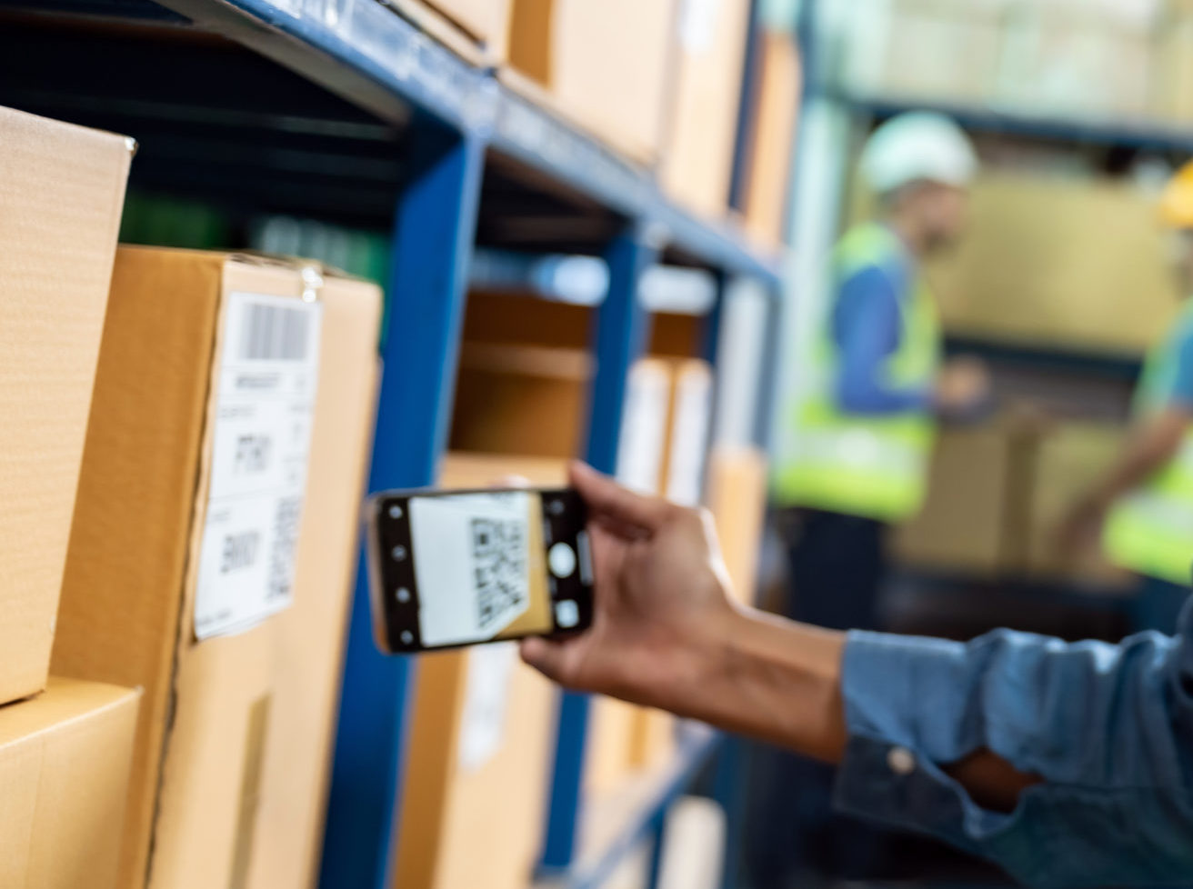 Worker scanning a warehouse package for accurate electronics inventory management